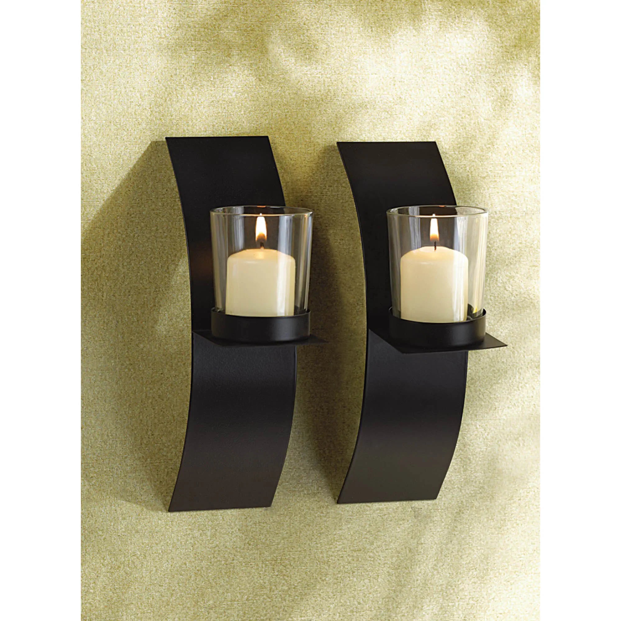 Two black wall-mounted candle holders with lit candles on a textured wall.