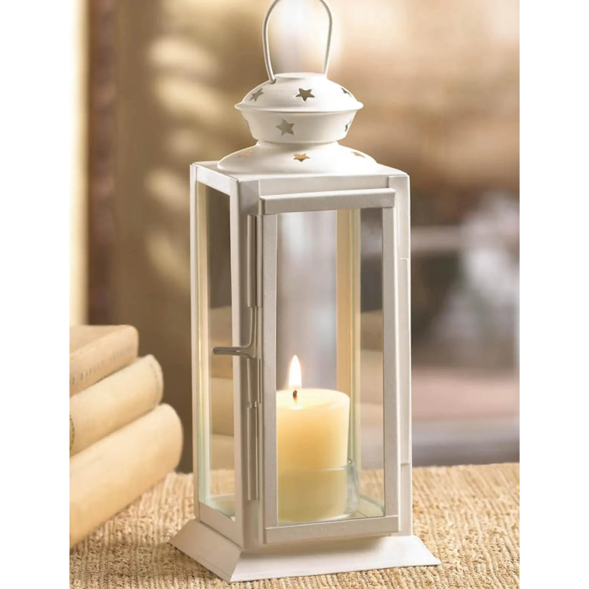 White lantern with a lit candle inside on a textured surface.