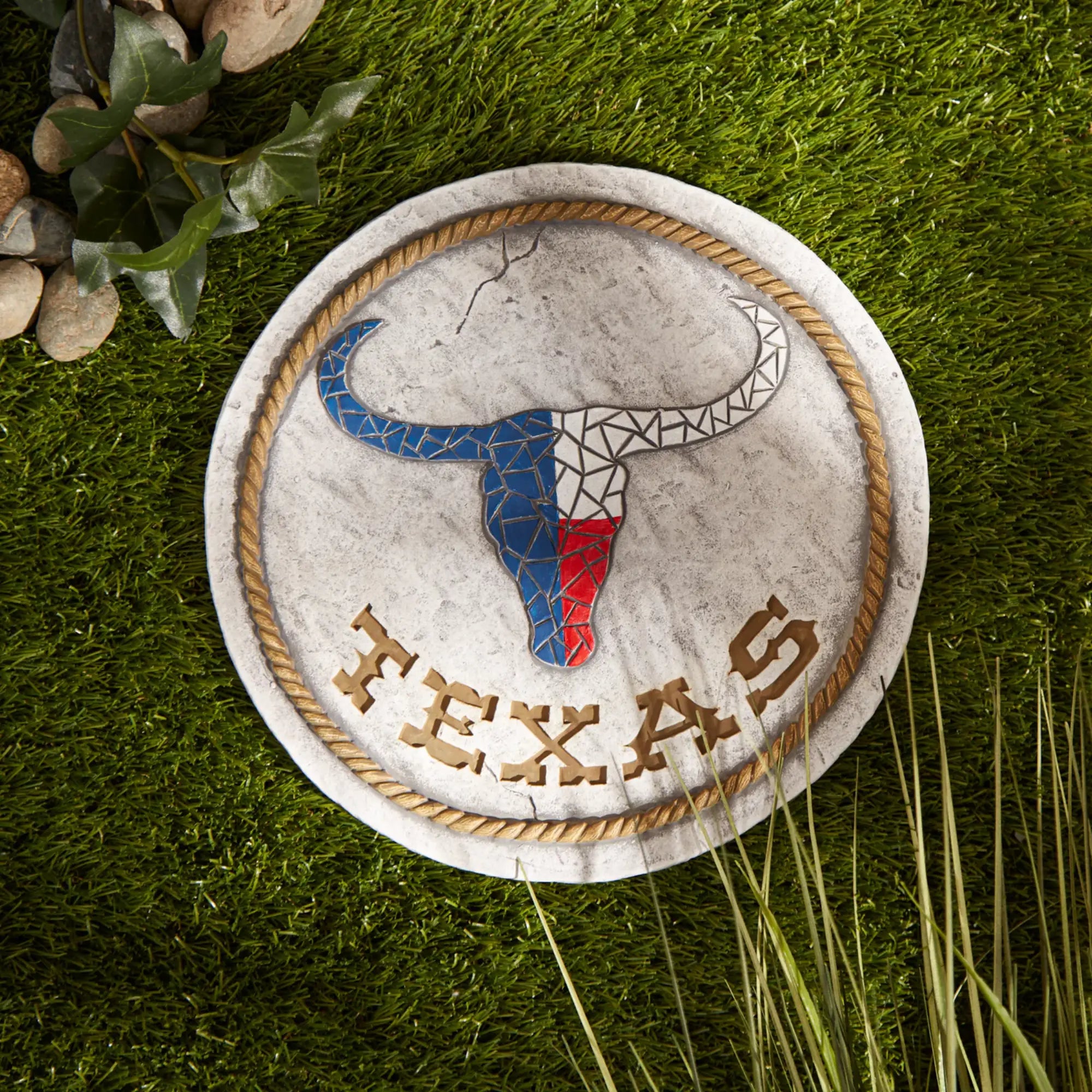 Garden stepping stone with a bull head design and 'Texas' text on grass
