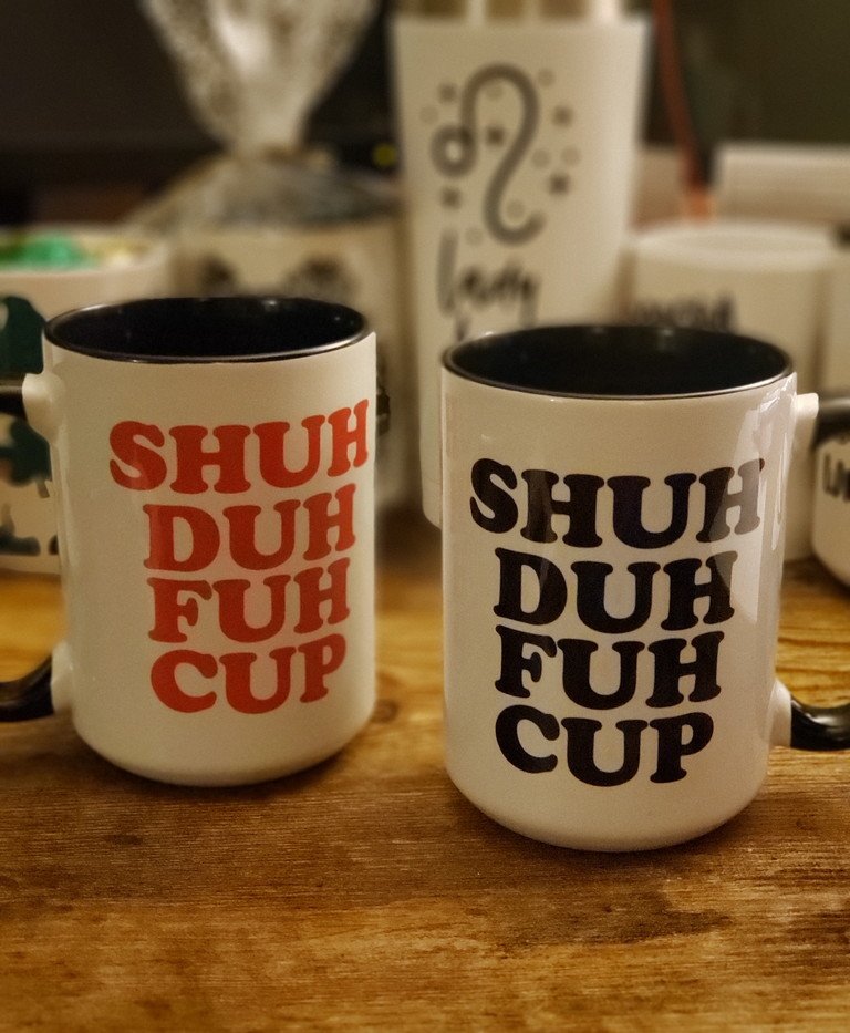 Shuh Duh Fuh Cup novelty mugs shown with black and red print