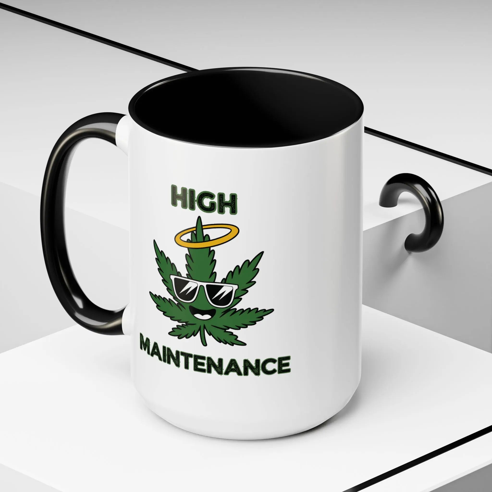 White mug with black interior and handle, featuring a cannabis leaf graphic and text 'High Maintenance' on a light gray background.