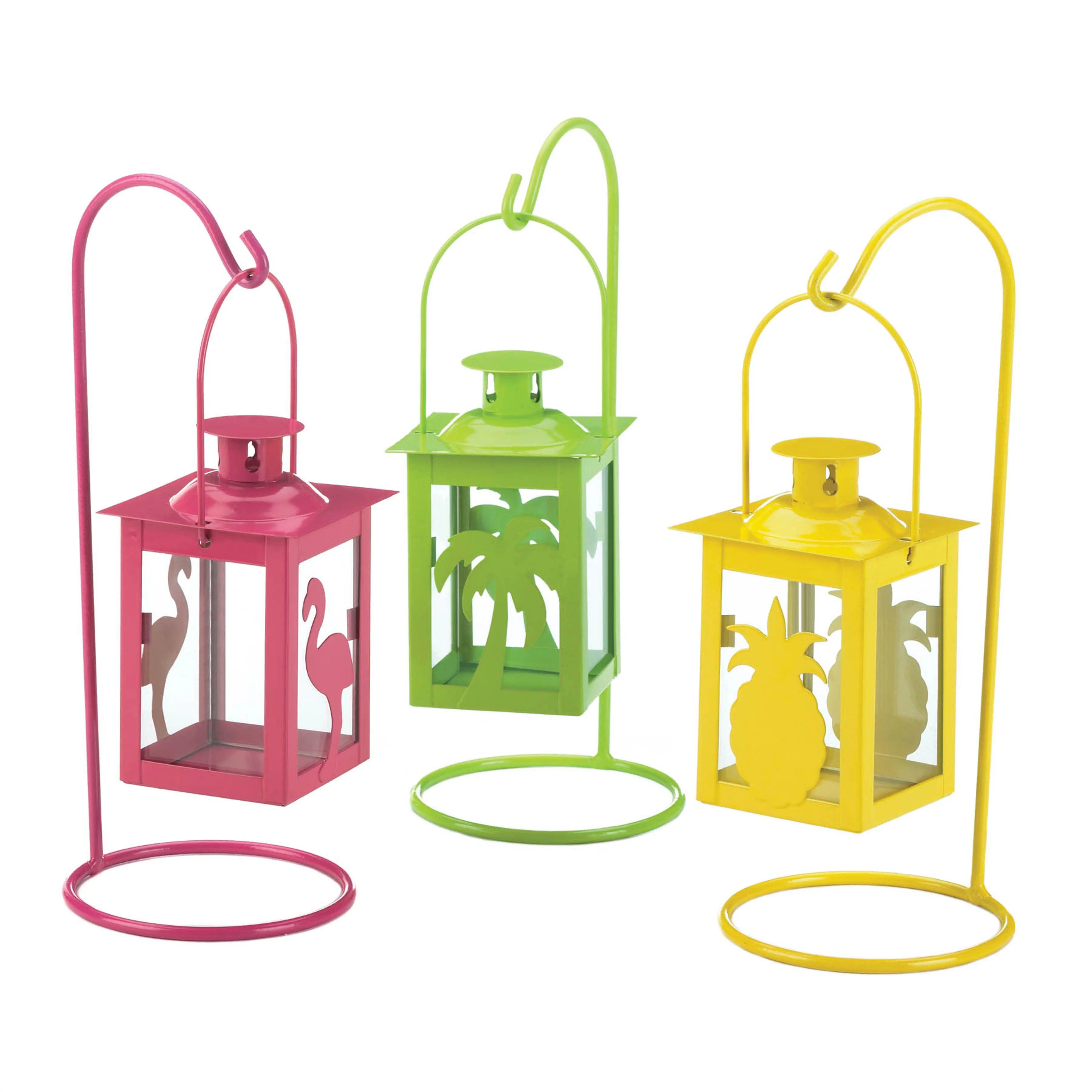 Three colorful metal lanterns with decorative cutouts on a white background