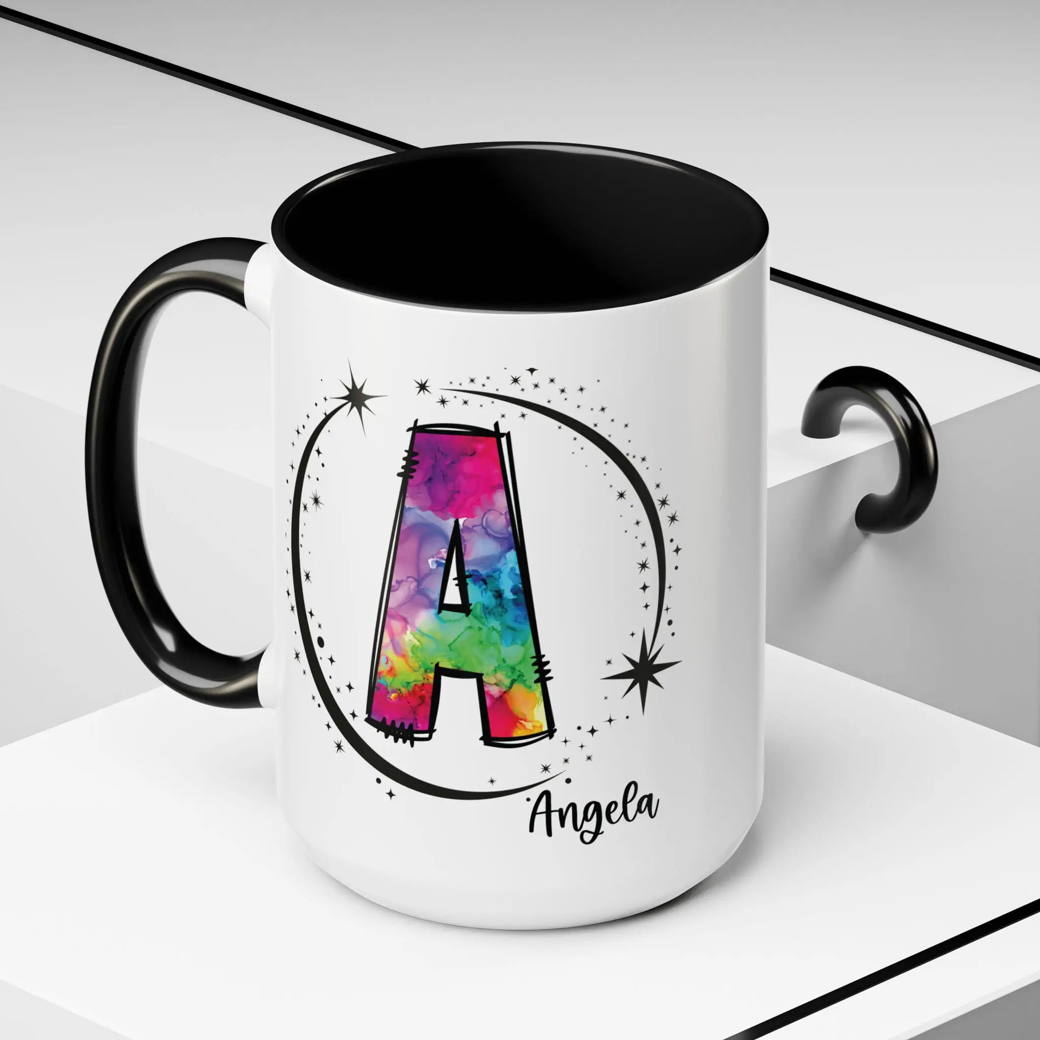 Monogram mug with black handle and interior featuring a colorful letter A design and custom name on lifestyle background