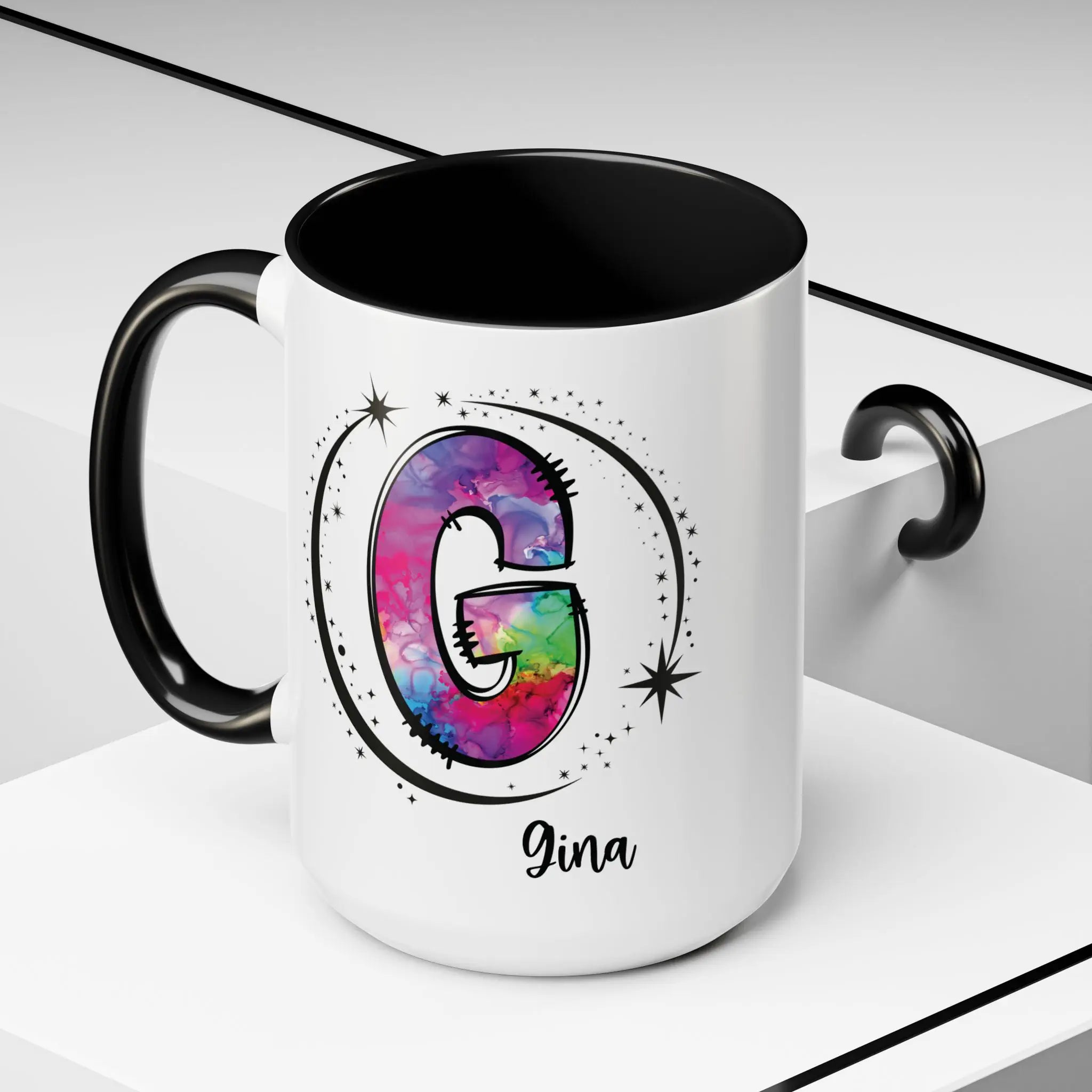 White monogram mug with black handle and interior featuring a colorful letter G design and custom name on decorative background