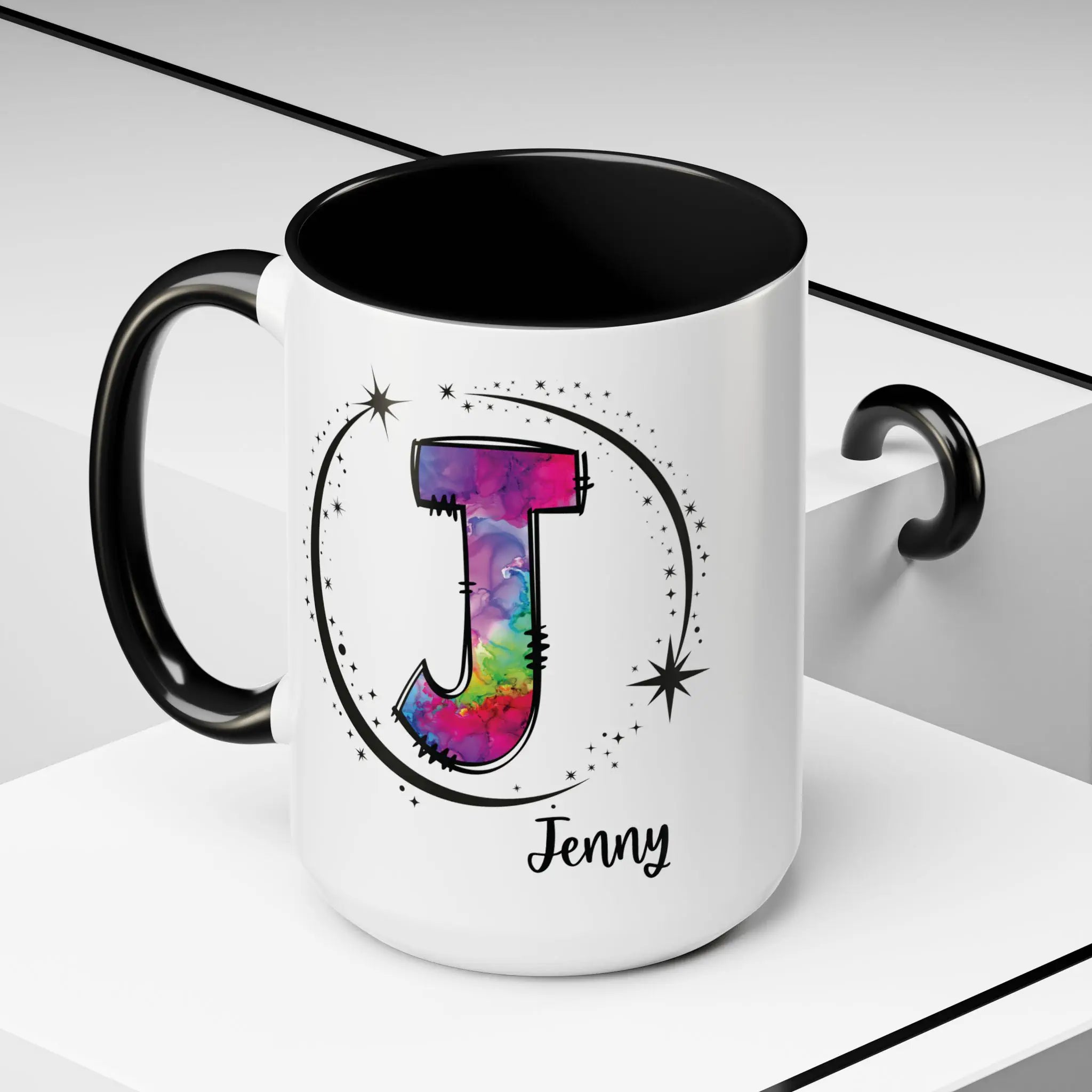 Monogram mug with black handle and interior featuring a colorful letter J design and custom name on decorative background