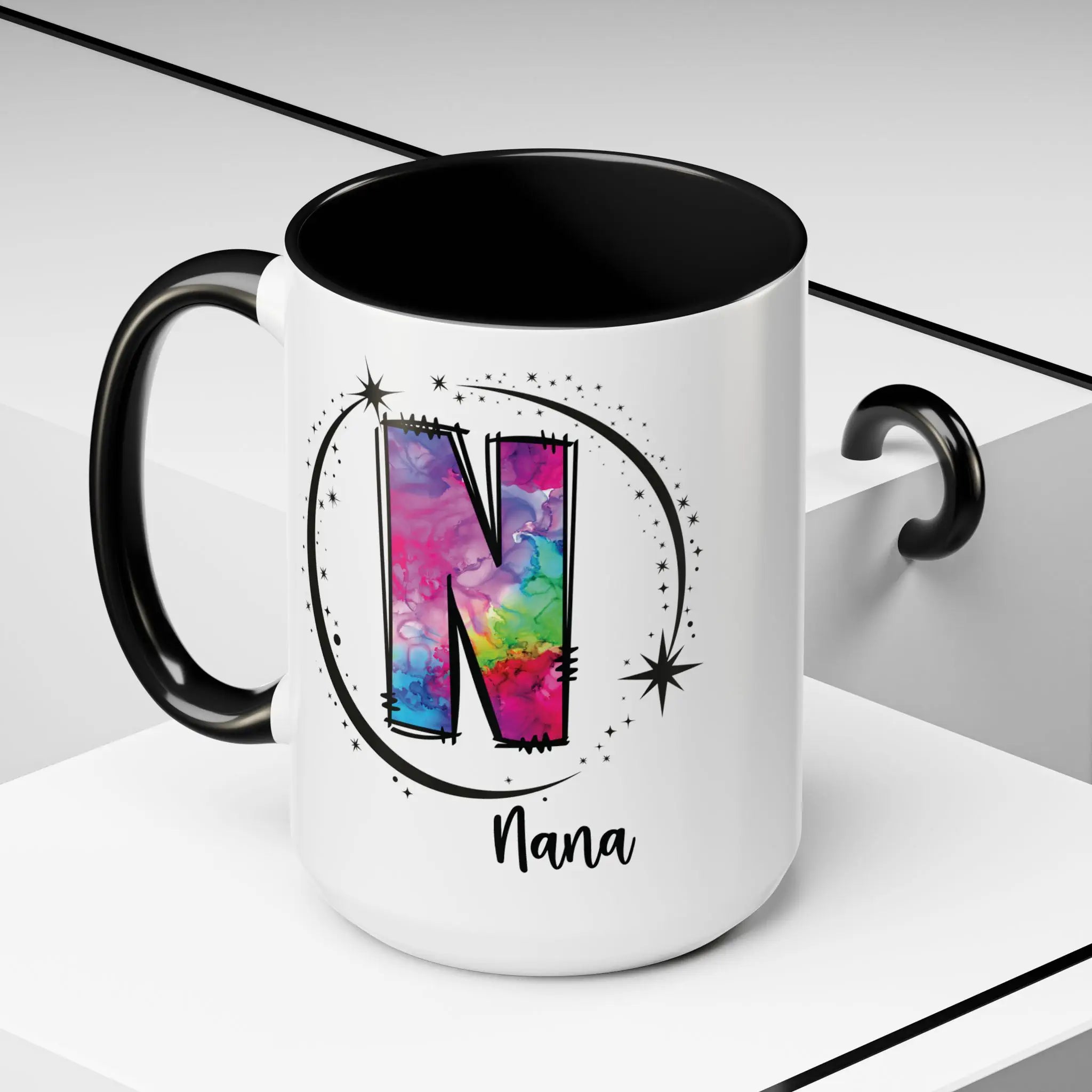 White monogram mug with black handle and interior featuring a colorful letter N design and custom name on decorative background