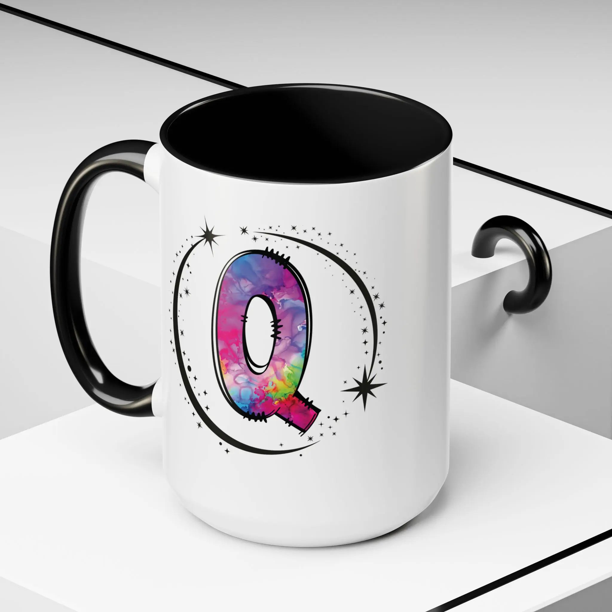 Monogram mug with black handle and interior featuring a colorful letter Q design and custom name on decorative background
