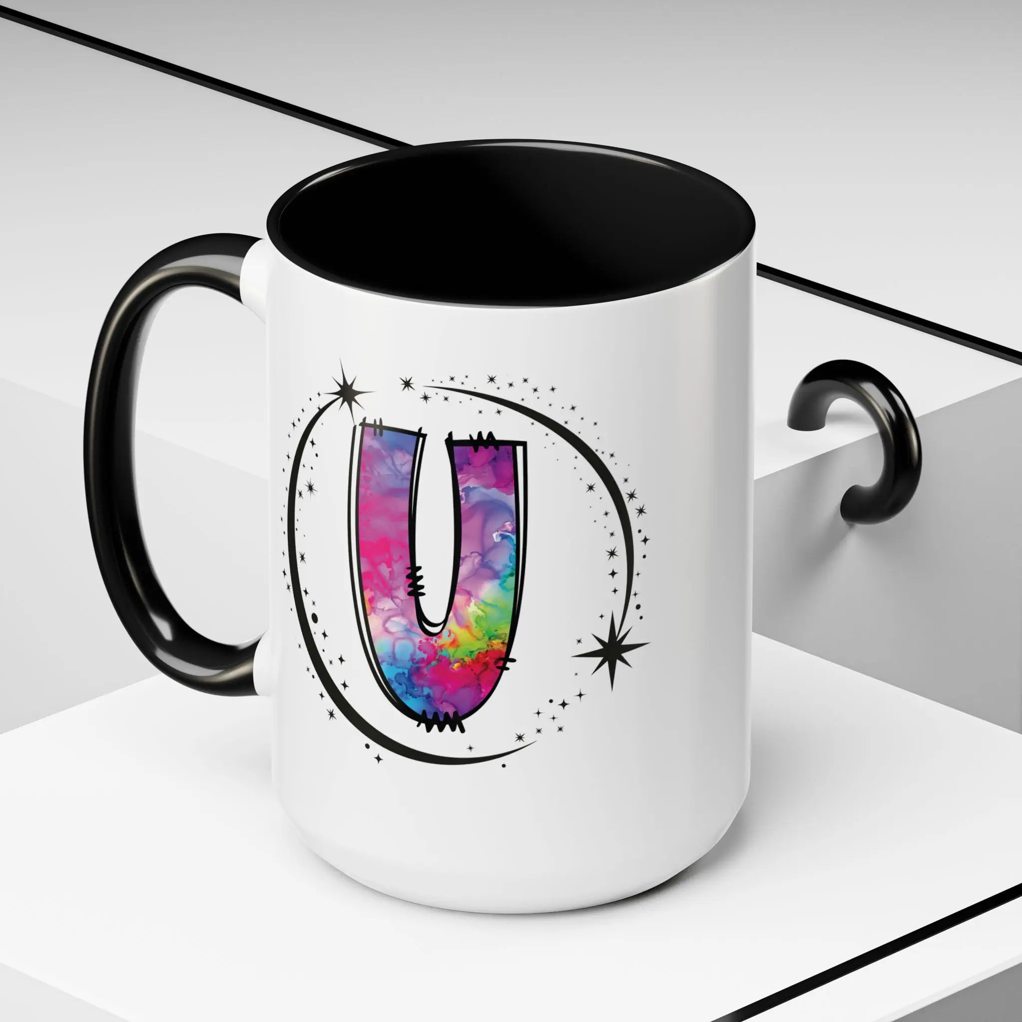 White monogram mug with black handle and interior featuring a colorful letter U design and custom name on decorative background