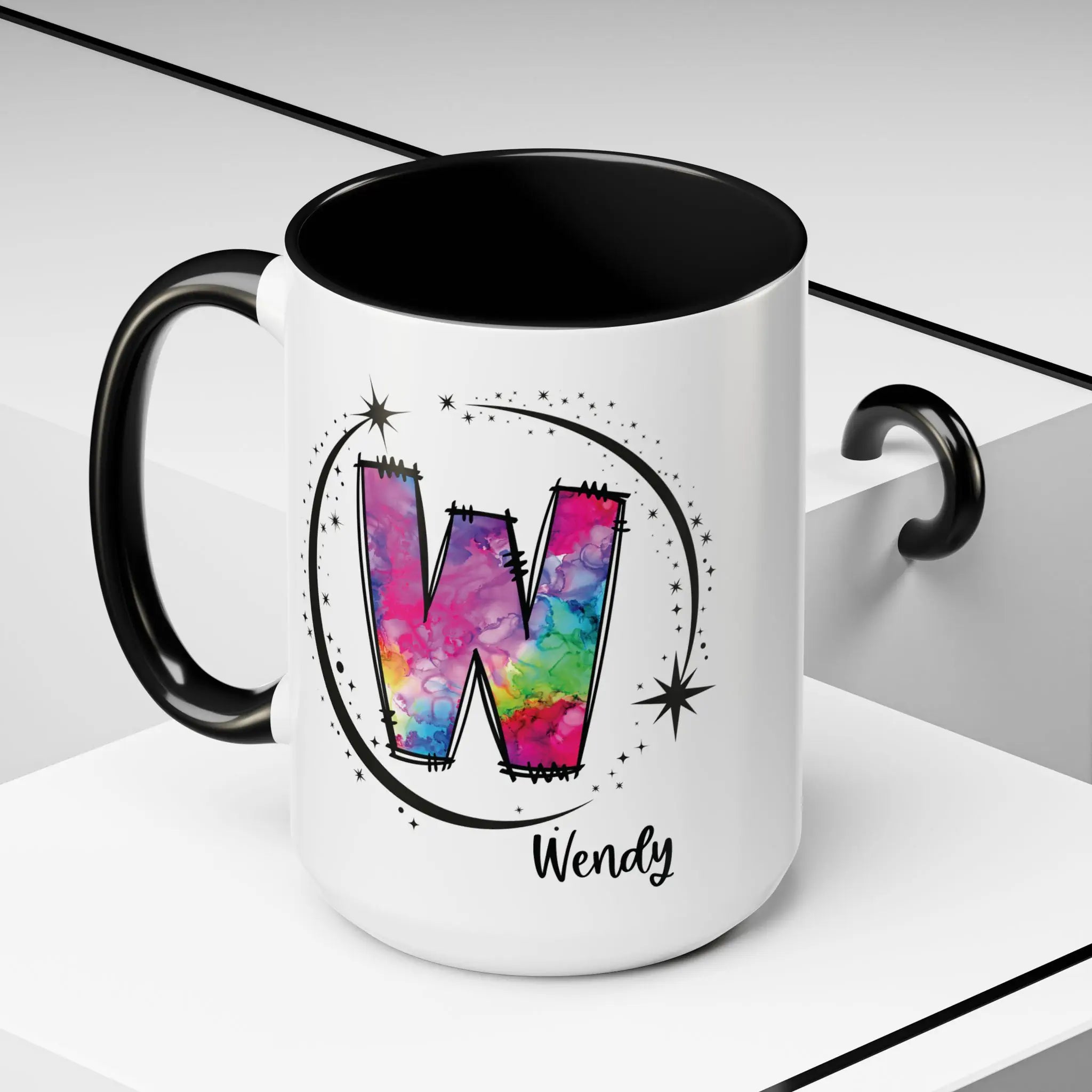 Monogram mug with black handle and interior featuring a colorful letter W design and custom name on decorative background