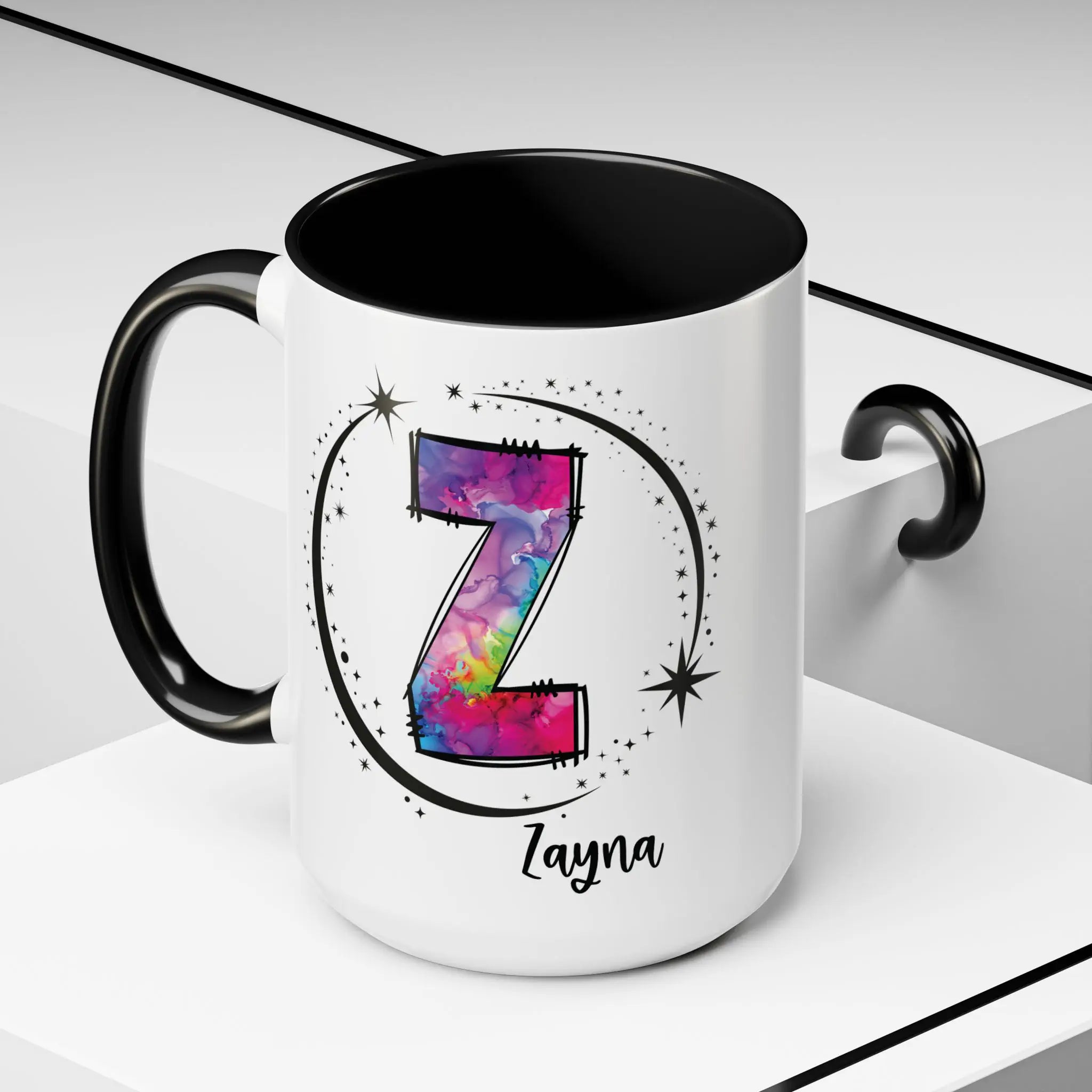 White monogram mug with black handle and interior featuring a colorful letter Z design and custom name on decorative background