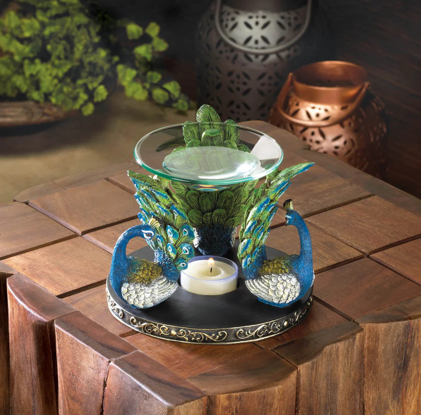 Decorative oil burner with peacock design on a wooden table